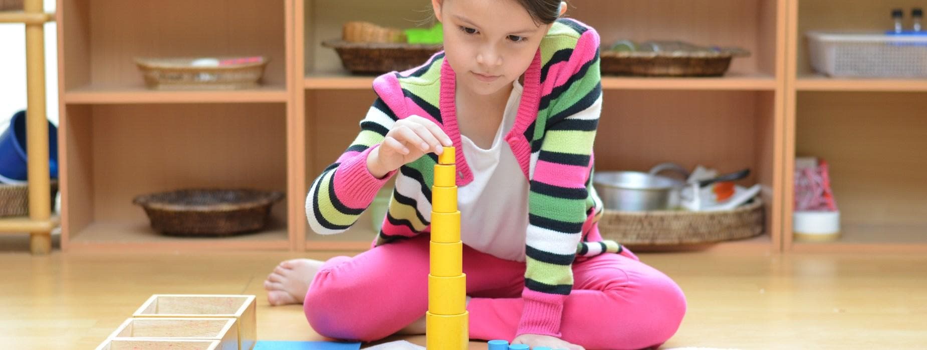 Niña del Colegio concentrada, construyendo con material Montessori