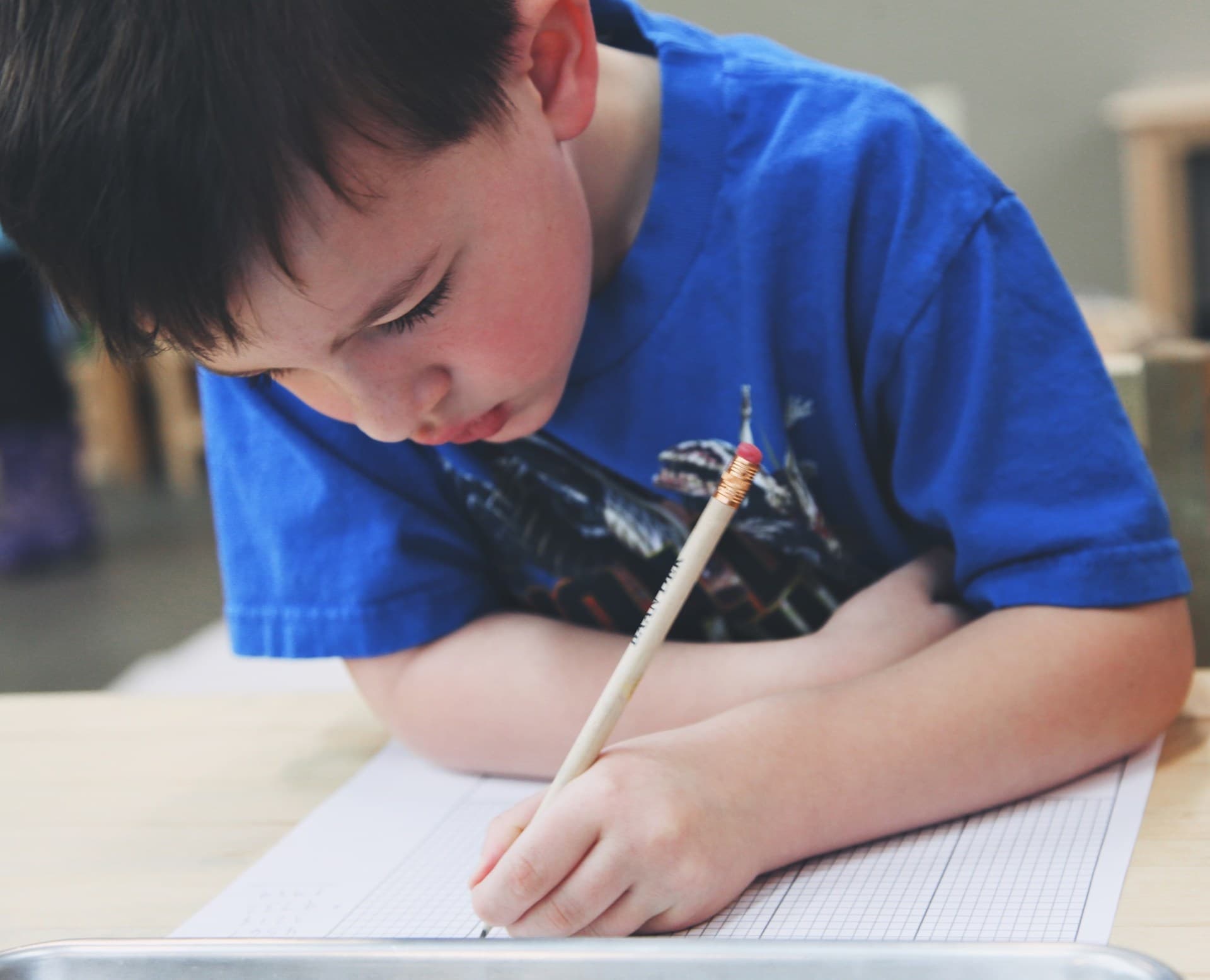 Niño del Colegio Edgar Morin escribiendo con concentración en clase